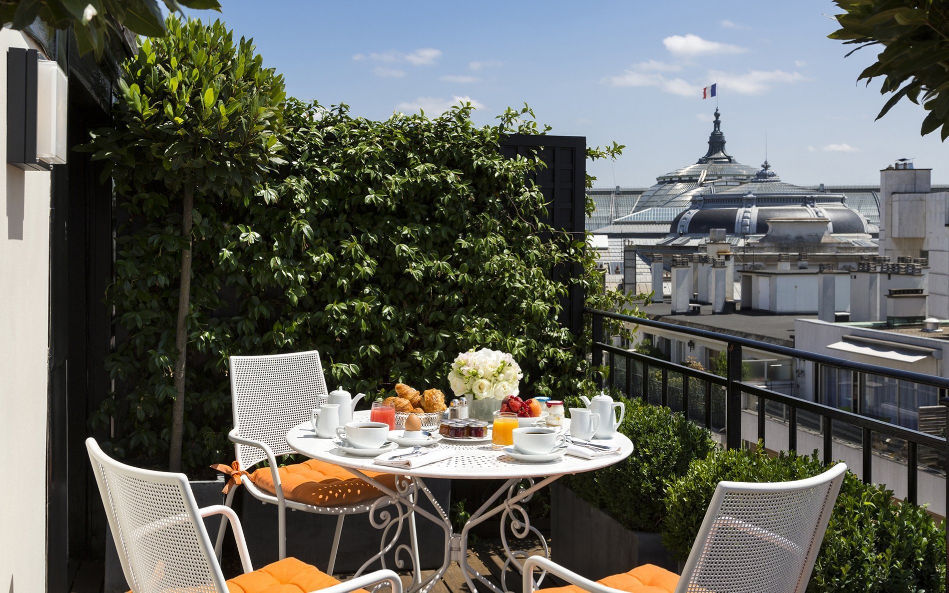 Petit déjeuner sur la terrasse de la Terrace Junior Suite de l’Hôtel San Régis, avec vue sur le Grand Palais à Paris.